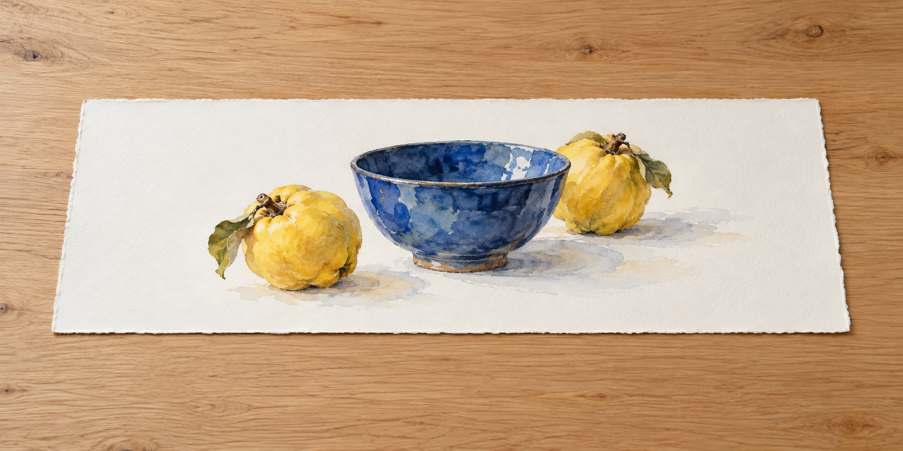 青い器と左右に置いた二つの黄色の実を描く横長の水彩画を、木の机に置いている。