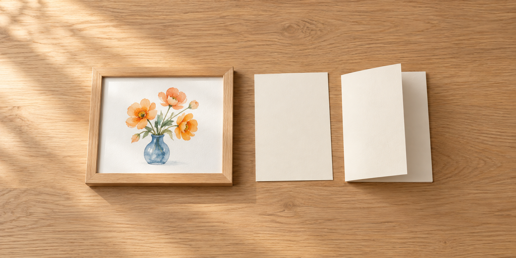 小さな木枠の花の絵と、二種類の無地の案内紙を木の机に並べている。