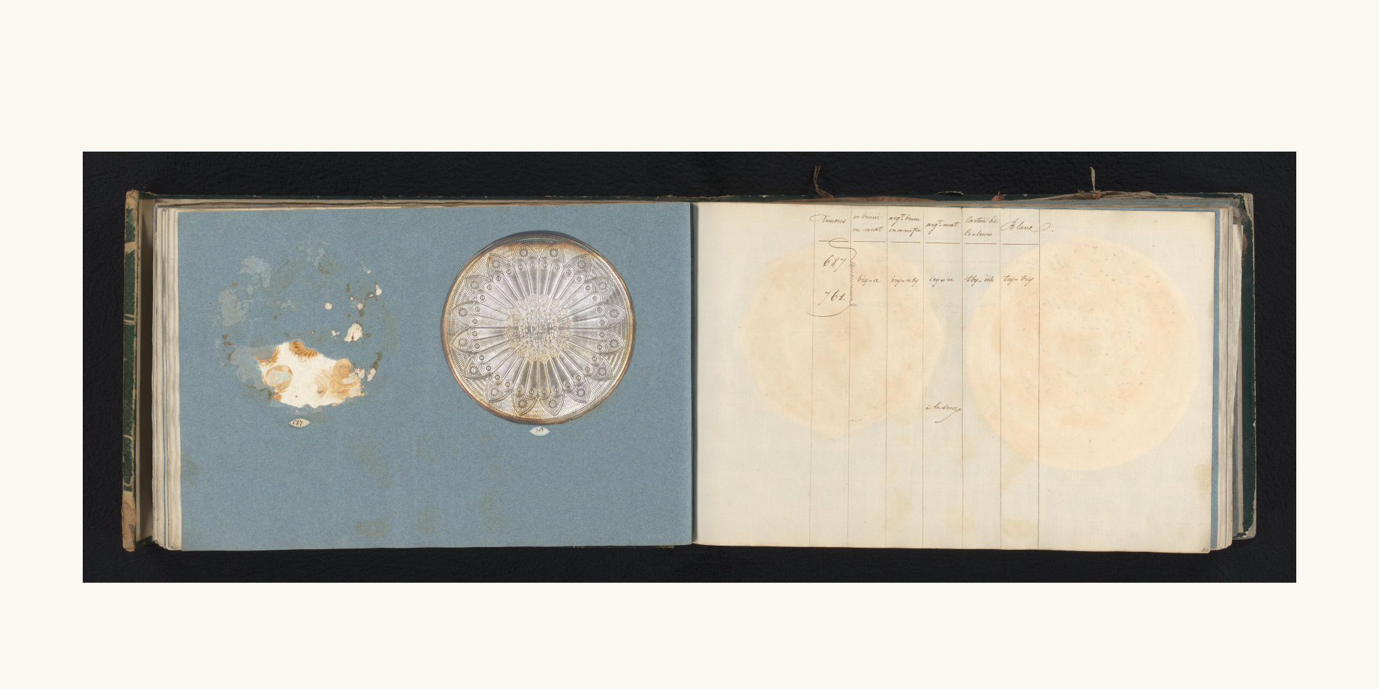 青い左ページの円形見本と番号ラベル、右ページの手書き表が並ぶRijksmuseum所蔵見本帳の見開き。